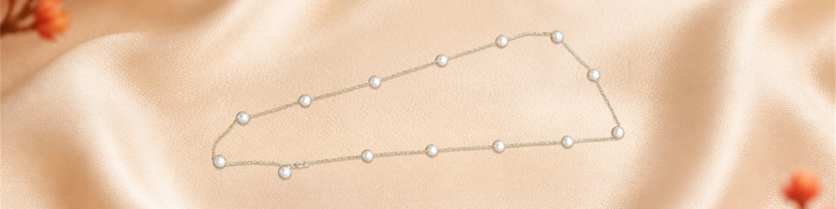 Pearl necklace photographed on champagne silk with red flowers