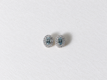 Blue oval gemstone halo silver stud earrings view 1