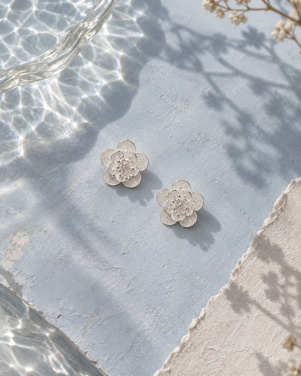 Handcrafted silver floral earrings flat lay