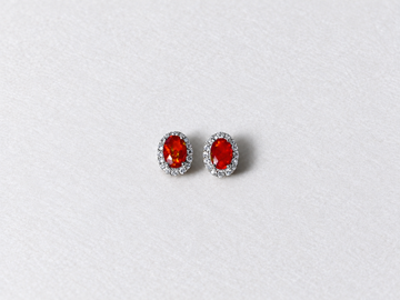 Red oval gemstone halo silver stud earrings view 1